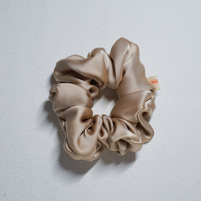 Beige scrunchie on a light gray background