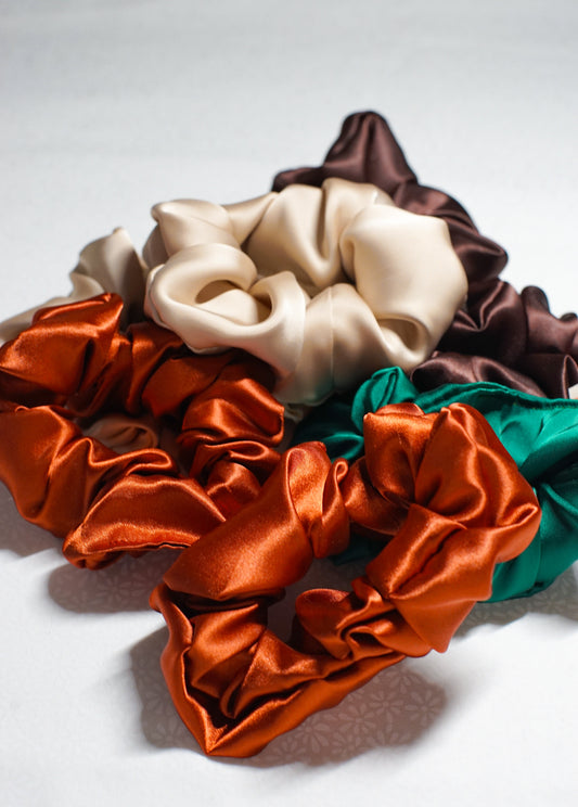 Set of colorful satin scrunchies on a white background