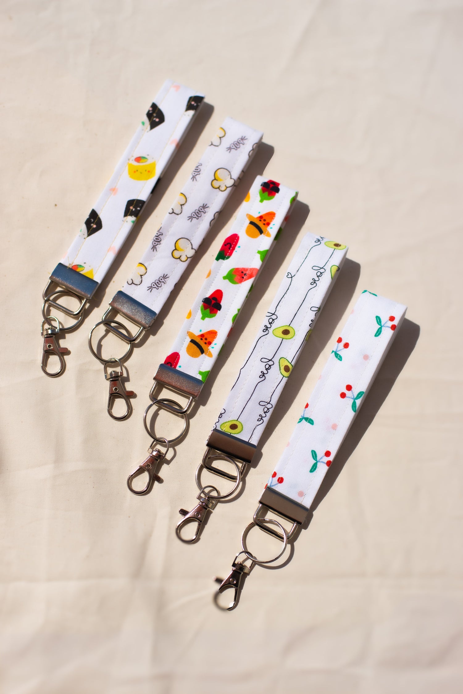 Set of three keychains with different patterns on a beige background